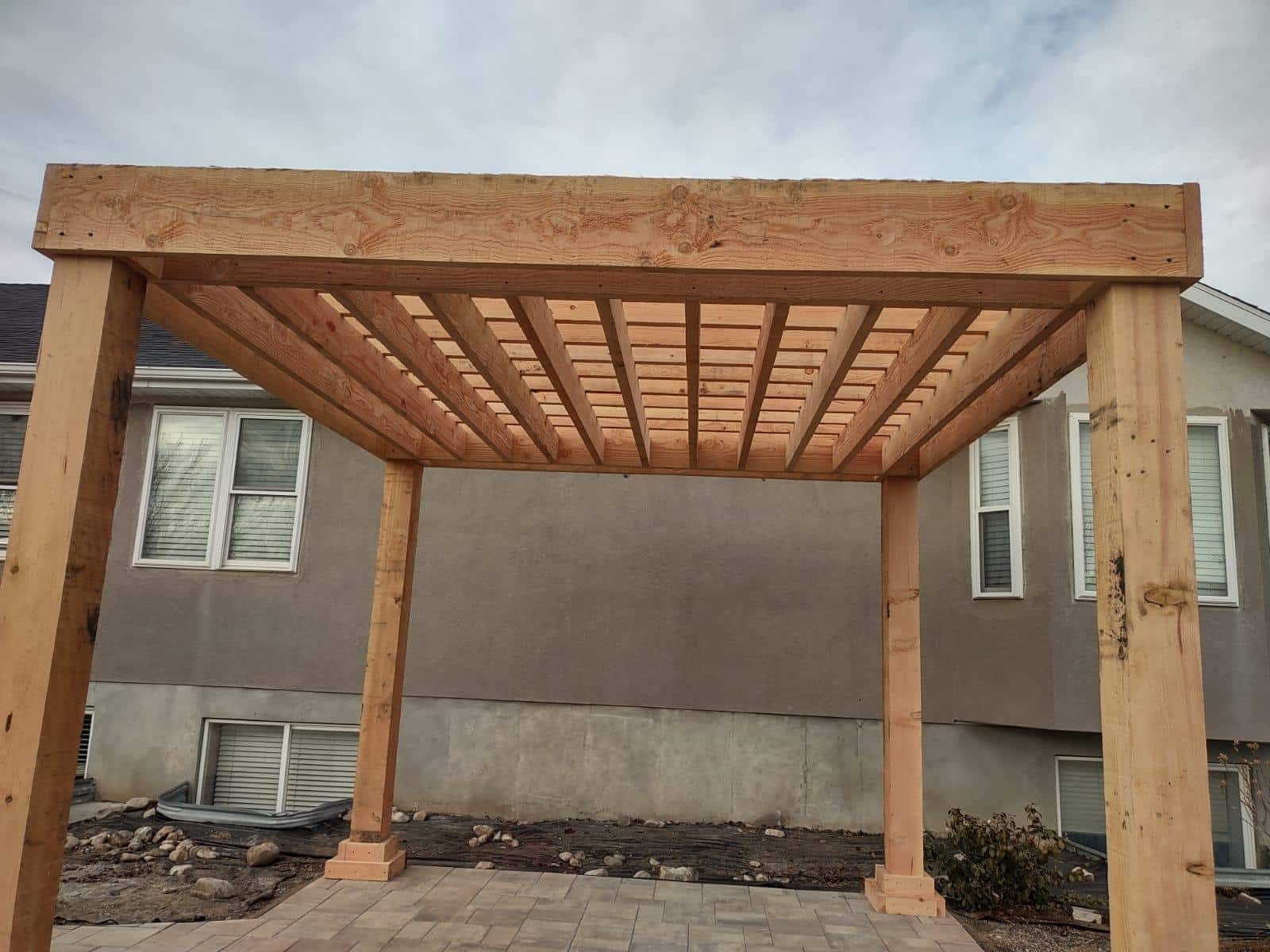 FORMAL PERGOLA 12 X 12 front view of a pergola near a grey home