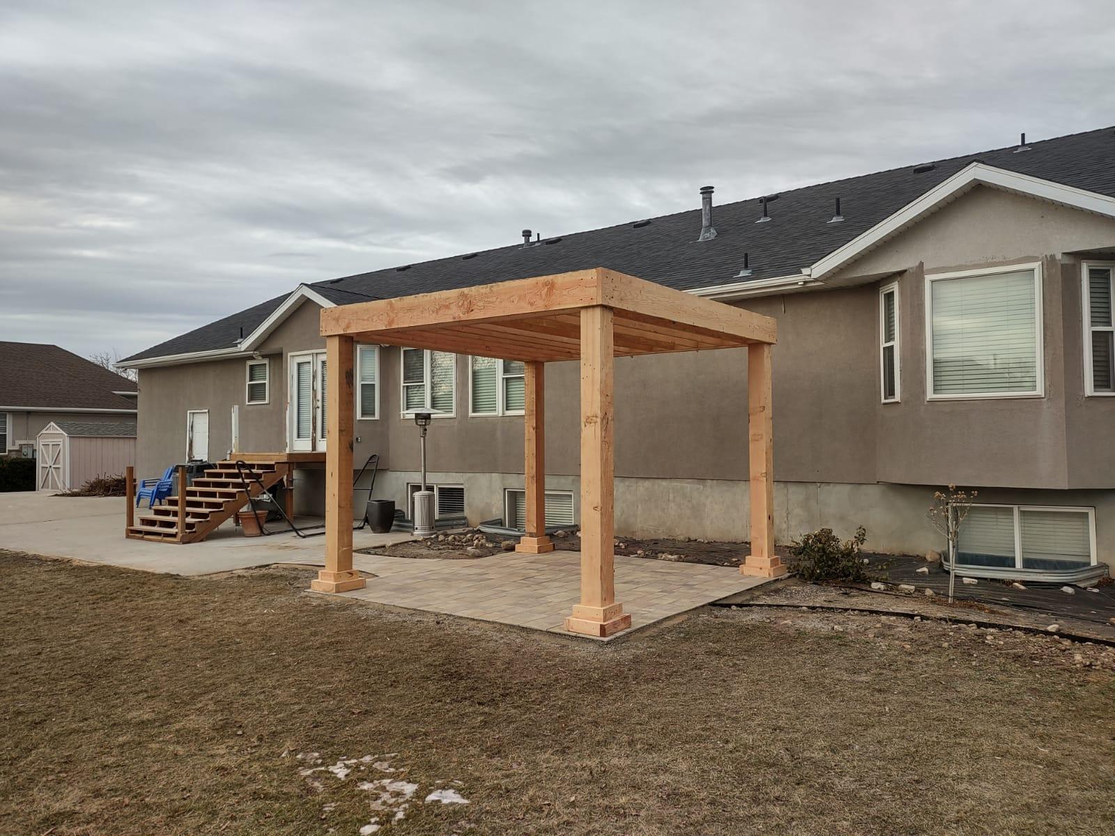 FORMAL PERGOLA Frame of a pergola being constructed in a backyard
