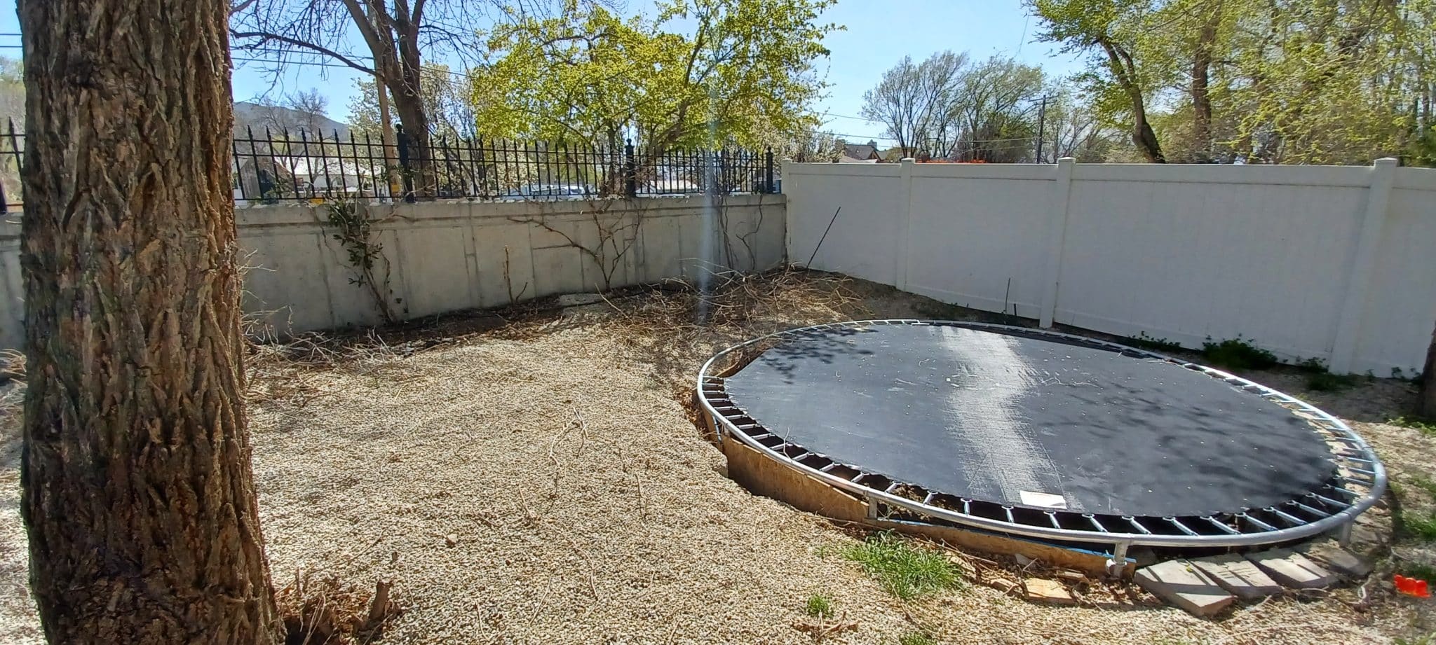 BLOCK RETAINING WALL (BEFORE2) Floor level trampoline in backyard