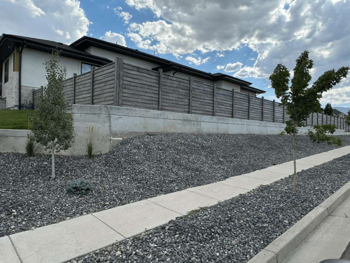 Screen Shot 2024-08-08 at 1.01.18 PM Retailing wall with gravel on the backside of a house.