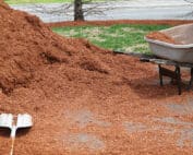 Pile of mulch, wheelbarrow and scoop shovel