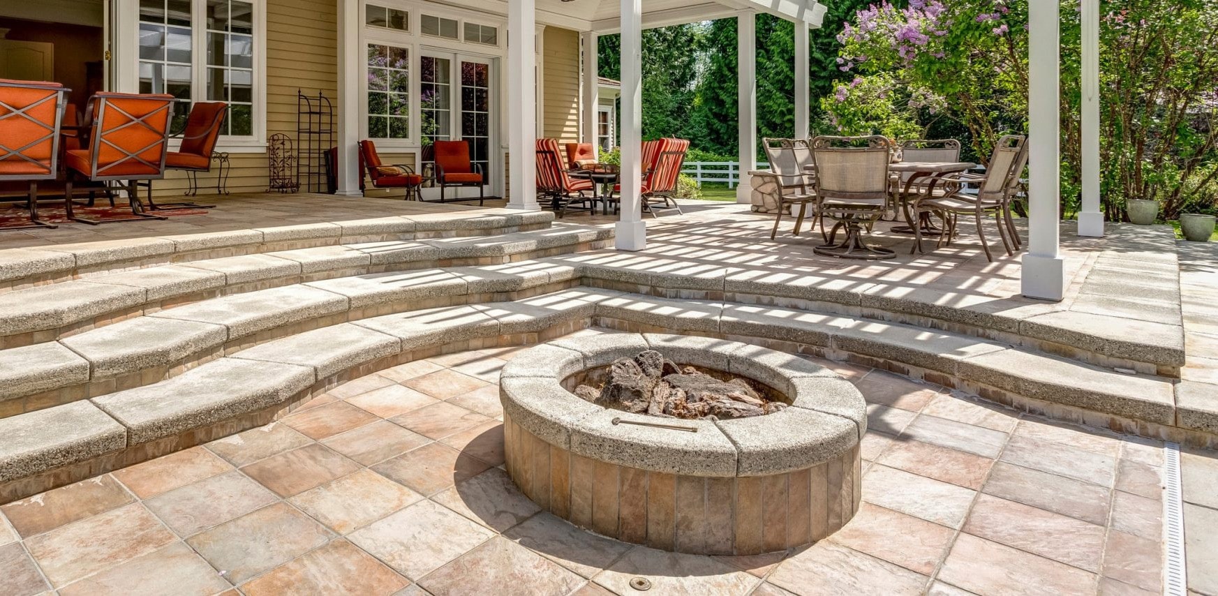 Backyard landscape with paver patio, stairs, fire pit, trees and turf