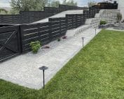 Backyard with fence, gate, plant beds, paved walkway and fire pit